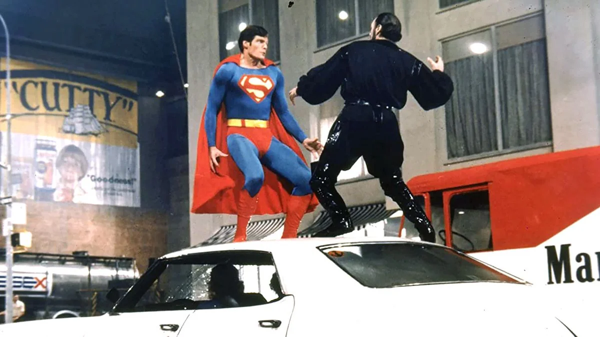 Christopher Reeve als Superman kämpft mit einem Mann auf einem Auto in einem der besten Superheldenfilme aller Zeiten, Superman 2.