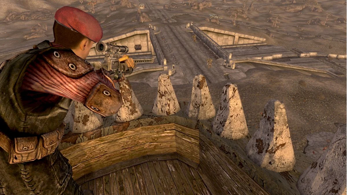 fallout-new-vegas-und-die-ruckkehr-zu-den-wurzeln-des-rollenspiels_img_2 | etalongame.de Fallout New Vegas Screenshot, der einen Scharfschützen zeigt, der von den Kiefern einer Dinosaurierstatue aus über das Ödland blickt