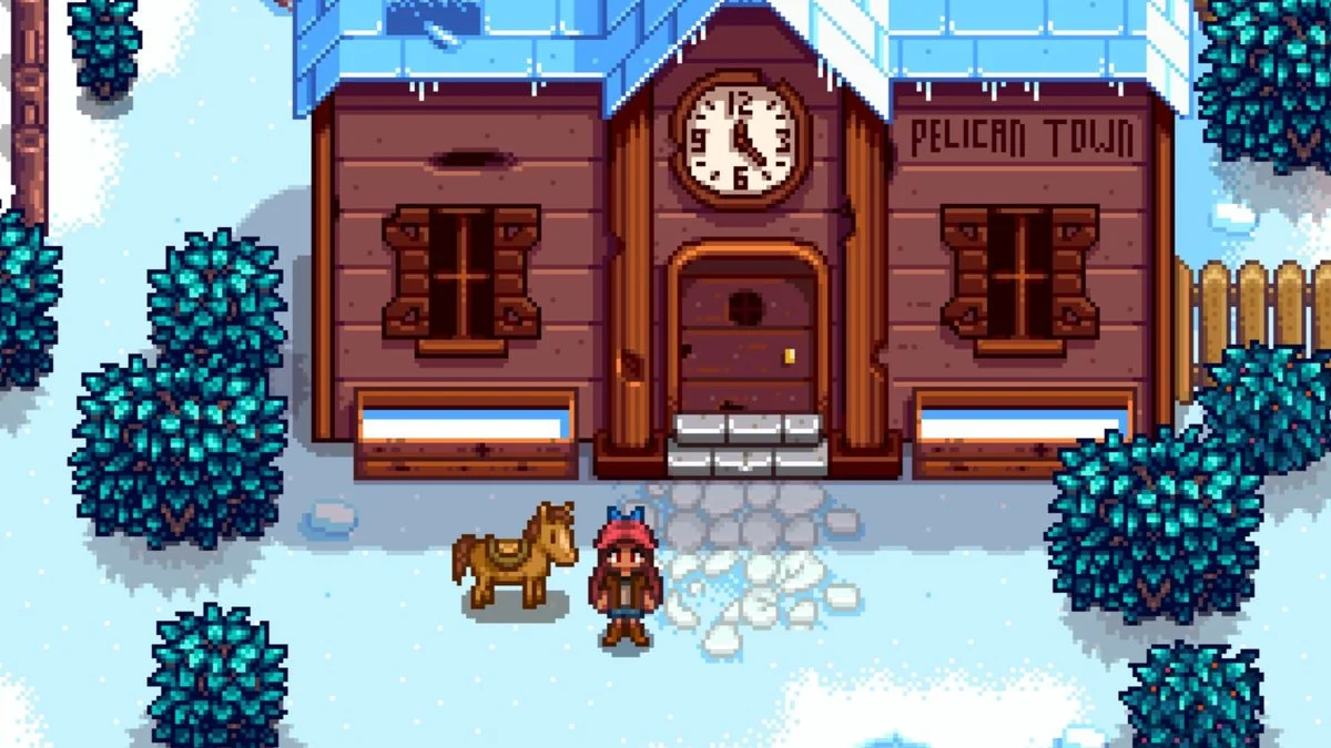 stardew-valley-so-aktiviert-man-cheats-ohne-mods_img_1 | etalongame.de Ein Stardew Valley Bauer steht im Winter vor dem Gemeindezentrum, links von ihr ist ihr Pferd.