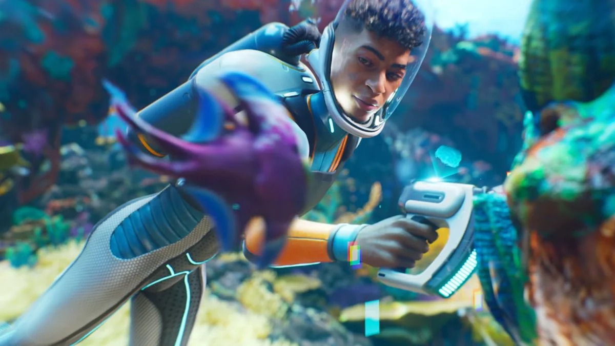 subnautica-2-fruhzugang-auf-2026-verschoben-erster-gameplay-teaser-veroffentlicht_img_0 | etalongame.de Ein junger Mann scannt ein Riff und betrachtet einen außerirdischen Fisch während des Trailers zu Subnautica 2.