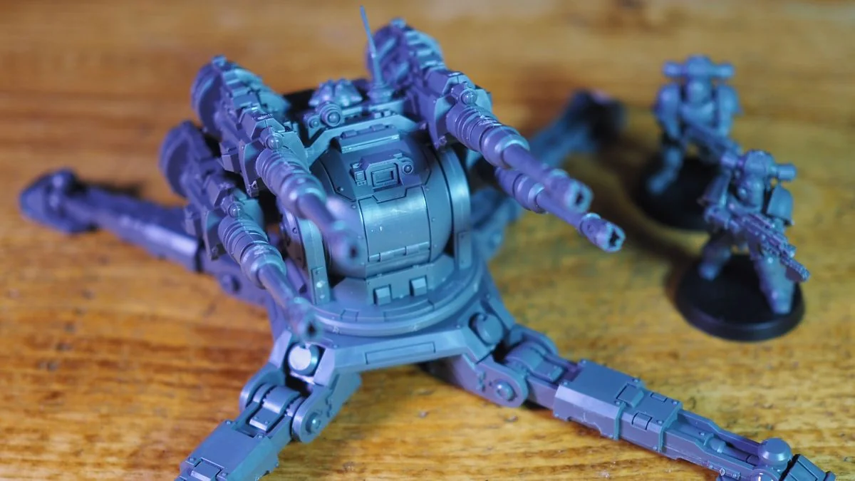 warhammer-the-horus-heresy-saturnine-ein-tiefgehendes-spielerlebnis_img_0 | etalongame.de Warhammer The Horus Heresy Saturnine Geschützturm und Modelle auf einer Holzoberfläche