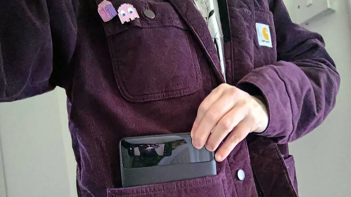 nintendo-switch-2-verlangerte-spielzeit-mit-der-baseus-blade-powerbank_img_1 | etalongame.de Phil trägt eine lila Carhartt-Jacke und zieht die Baseus Blade Powerbank aus der Tasche.